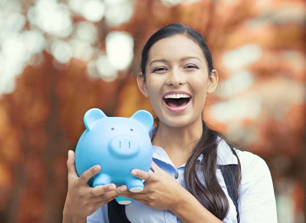 Closeup portrait happy, smiling business woman, bank employee holding piggy bank, isolated outdoors indian autumn background. Financial savings, banking concept. Positive emotions, face expressions Closeup portrait happy, smiling business woman, bank employee holding piggy bank, isolated outdoors indian autumn background. Financial savings, banking concept. Positive emotions, face expressions